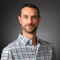 Professor John Hendrix headshot in a plaid shirt