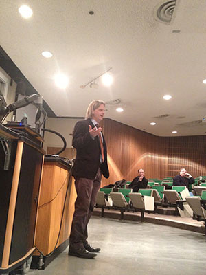Christensen presents at the front of a lecture hall