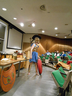 A student wears armor and performs in Knott Hall Basement Classroom