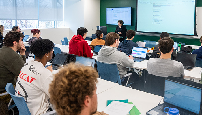 Students in a classroom look at screen together
