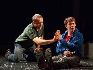 Two men touching hands on stage