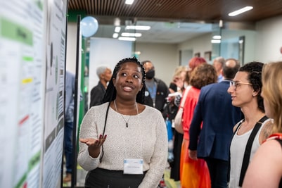 Student presents her research poster to visitors at Loyola's undergraduate research colloquium