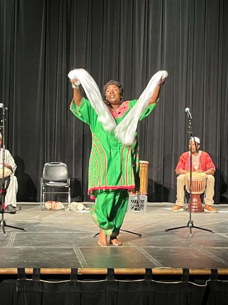 woman dressed in green dancing with white flowing scarves