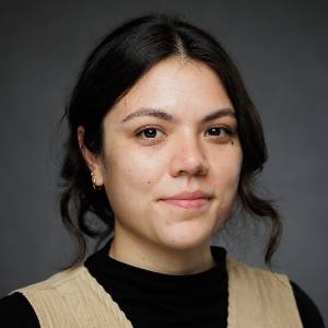 Headshot of a woman with dark hair on a grey background