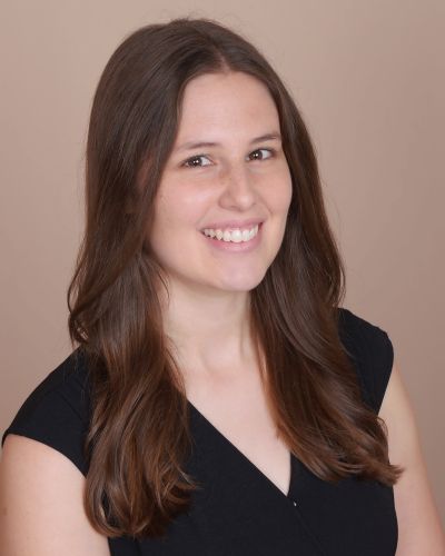 Rachel Sinclair in a dark top in front of neutral background