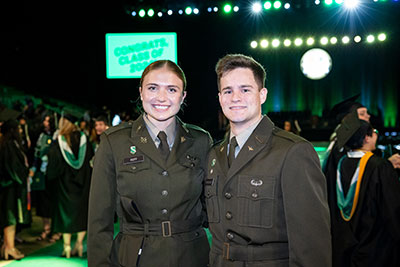 Two ROTC students in uniform smile for a photo at Loyola's graduation ceremony