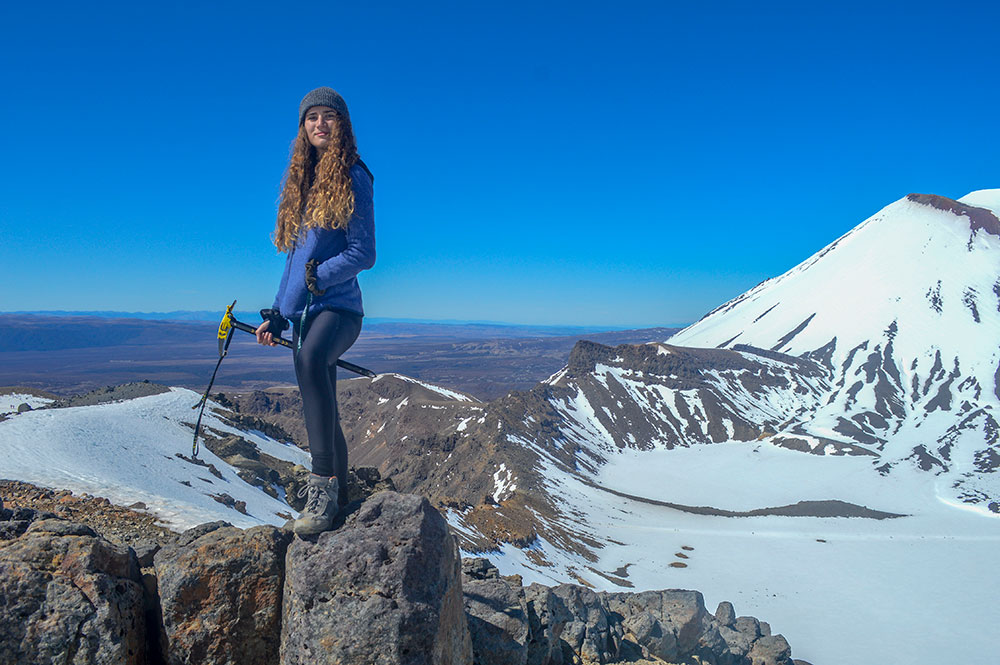 Student standing atop a snow mountain holding an ice pick