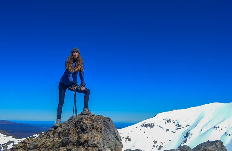 A student atop a snowy mountain