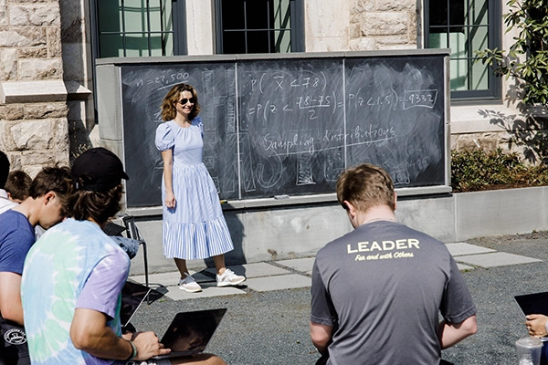 Professor works with students in outdoor classroom