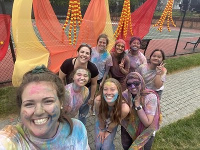 Group of students covered in paint, celebrating Holi