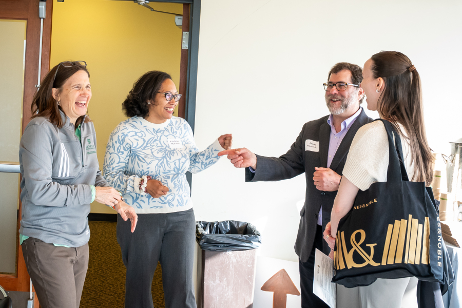 photo of group of individuals laughing and talking at CRE Symposium 2025