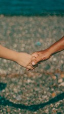 Two people holding hands while pulling away from each other