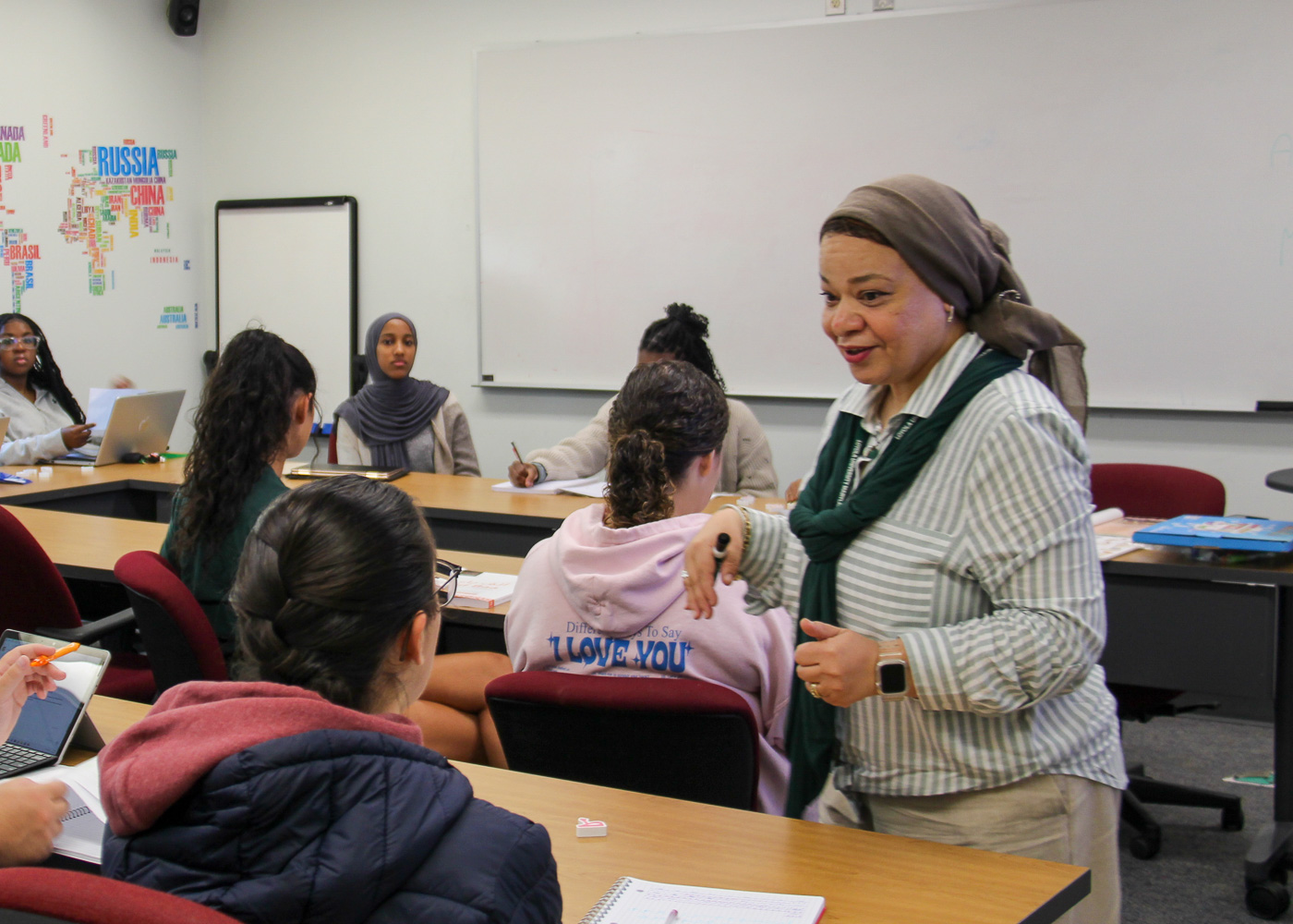 Professor interacting with students seated at desks