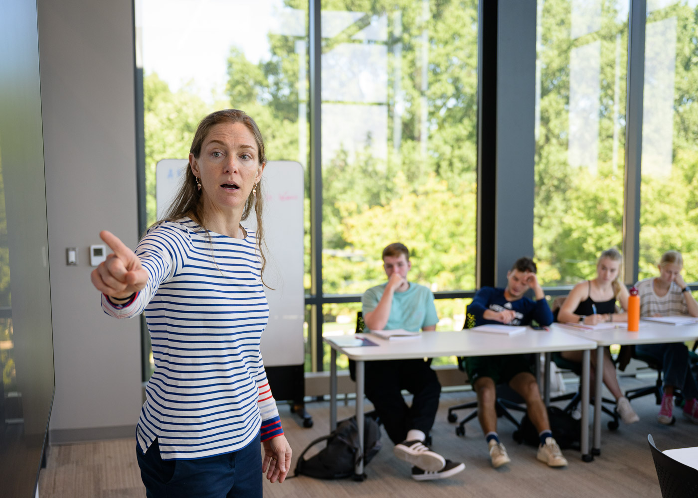 Professor pointing at a screen while instructing students