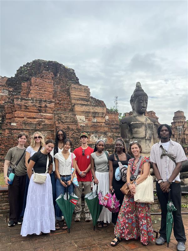 Lots of people gathering infront of a statue and building