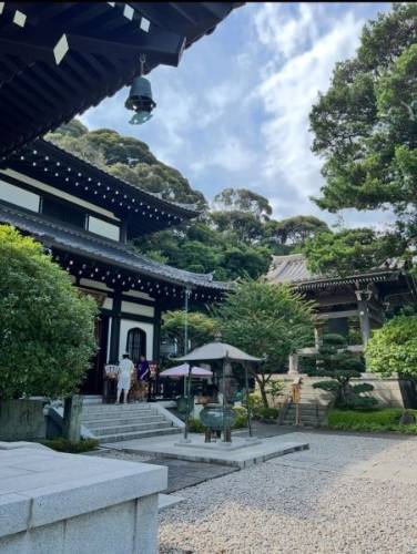 A temple in Japan with lots of trees and bushes around it