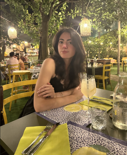 A girl looking at the camera sitting at a table