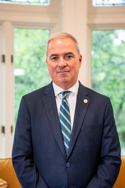 President Sawyer stands in an office