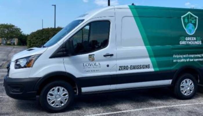 An electric vehicle with green greyhounds emblem and zero-emission label