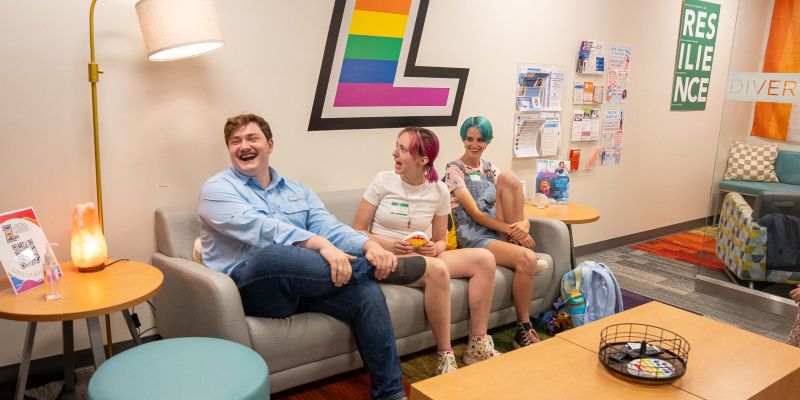 three people sitting and laughing in the thrive center lounge area