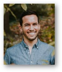 Patt Cassidy smiling in blue collared shirt with leaves in background