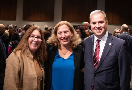 2 women and a man in an auditorium