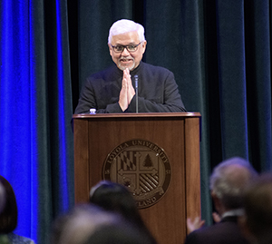 Amitav Ghosh delivering the keynote address with hands in a prayer sign