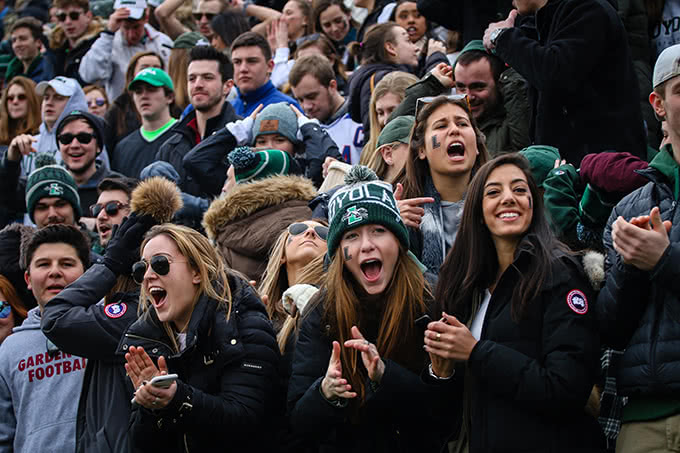 Students cheering with mouths open at lacrosse game