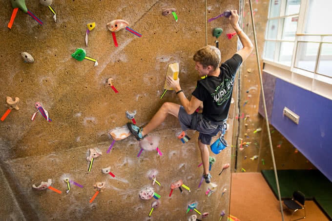 Student climbing on rock wall