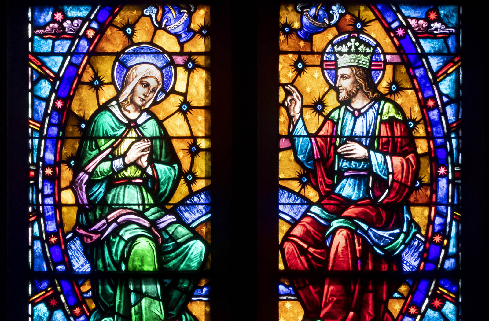 Detail photo of a colorful stained glass panel depicting the Assumption of Mary