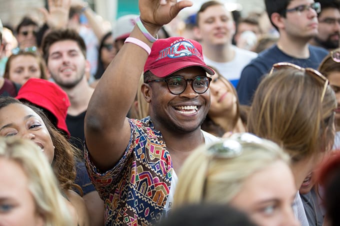 A student cheering within a large crowd