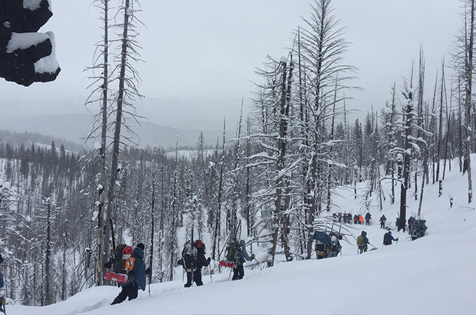 Students backpack through the snowy wilderness.