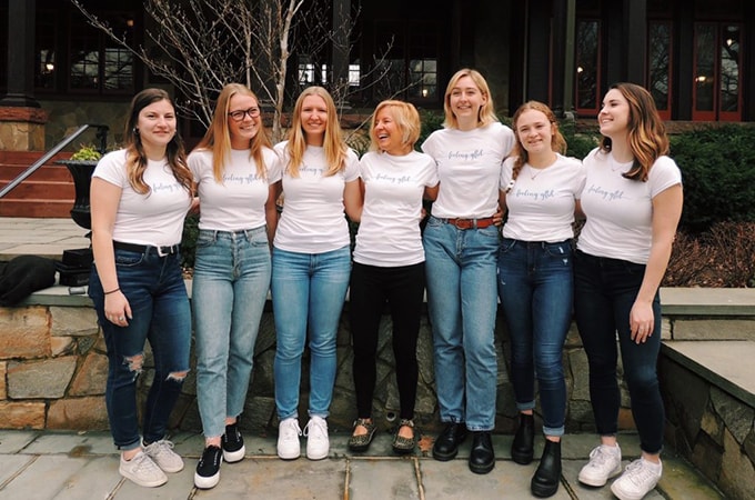 Group of students and faculty posing for a picture wearing matching 'feeling GFTD' t-shirts