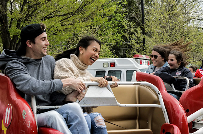 Students laughing while on a ride that spins