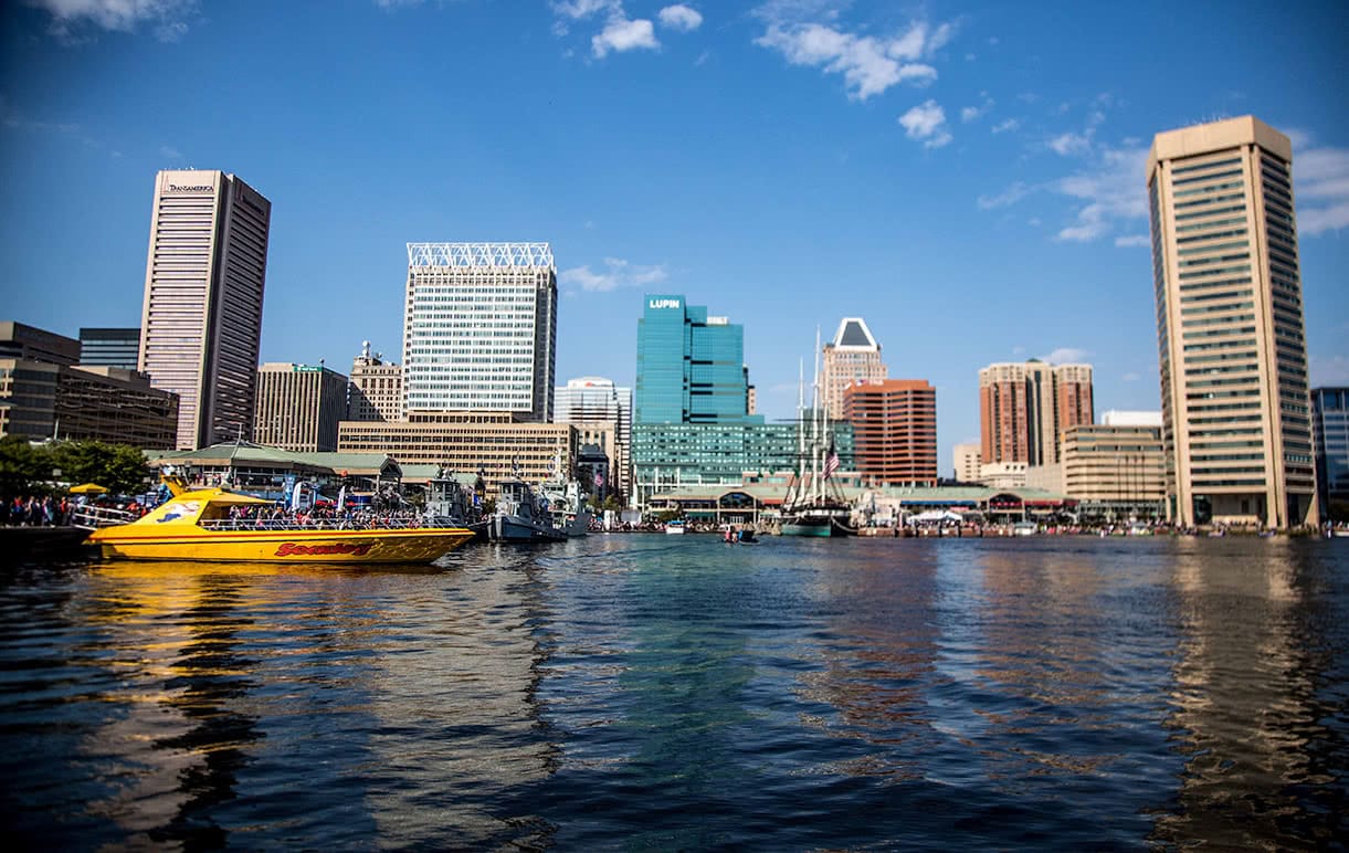 A view of the Baltimore Inner Harbor from the water, showing boats and buildings