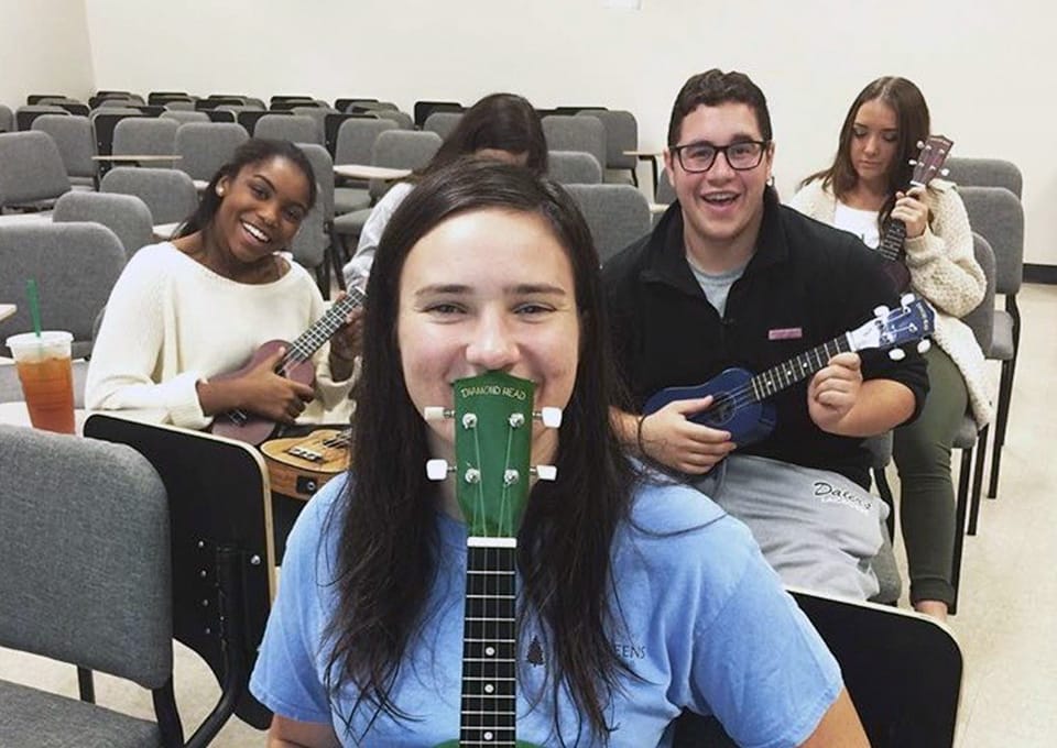Students with ukuleles sitting in classroom chairs