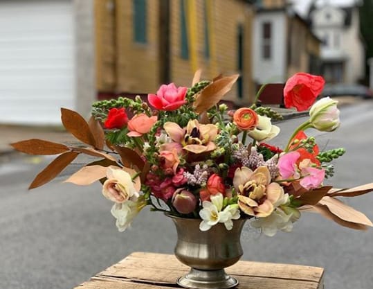 A vase full of flowers displayed outdoors