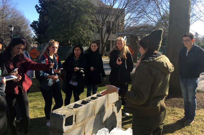 Media students interviewing a student building an outdoor art display