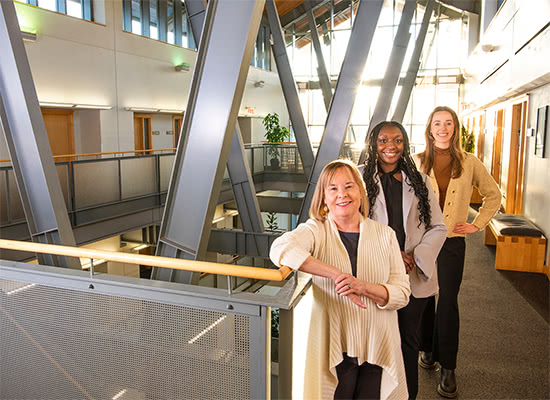 Andrea Giampetro-Meyer, Janae James, and Sydney Brooke pose for a photo in the Sellinger building