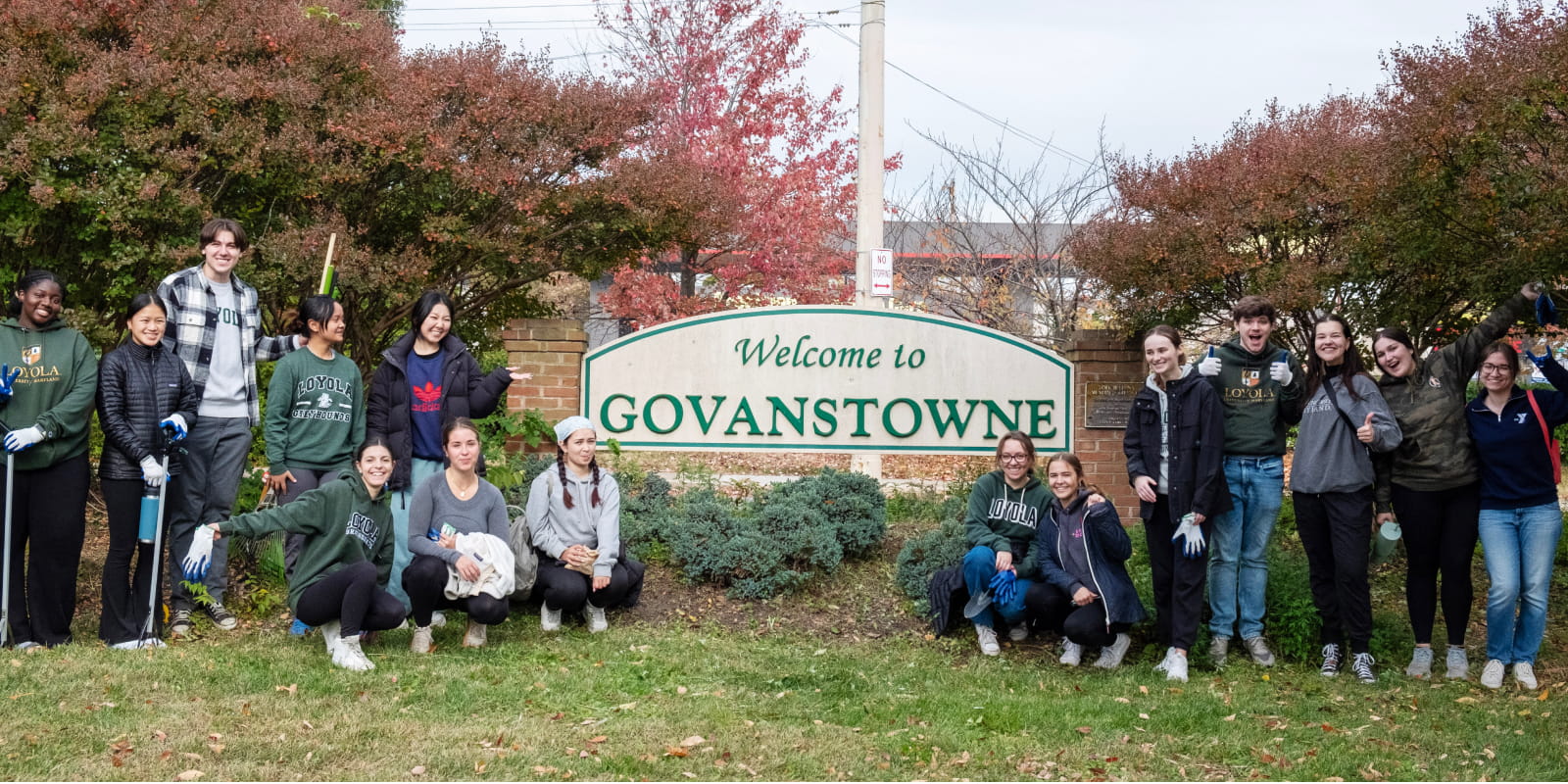 Volunteers pose in front of the Govanstowne sign