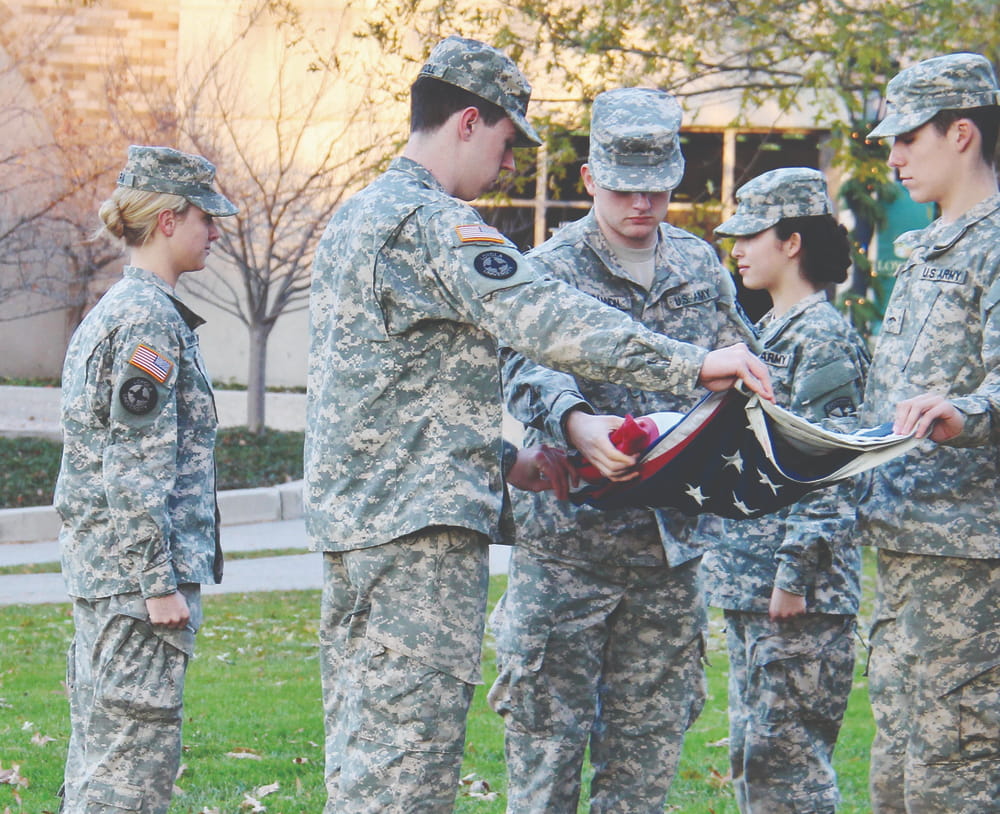 ROTC students in military uniforms folding the American flag