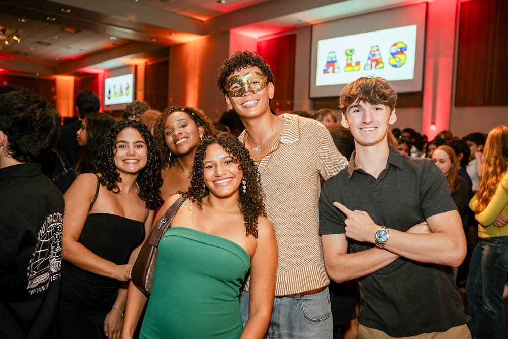 A group of students poses together at LatinFest during an indoor campus celebration