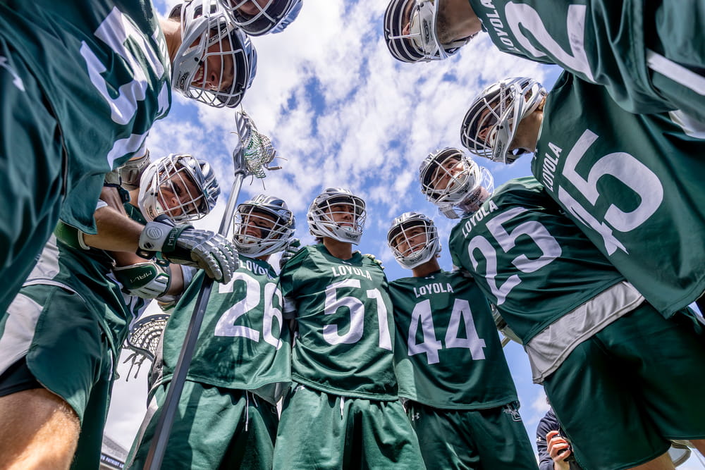 Members of the men's lacrosse team standing in a circle