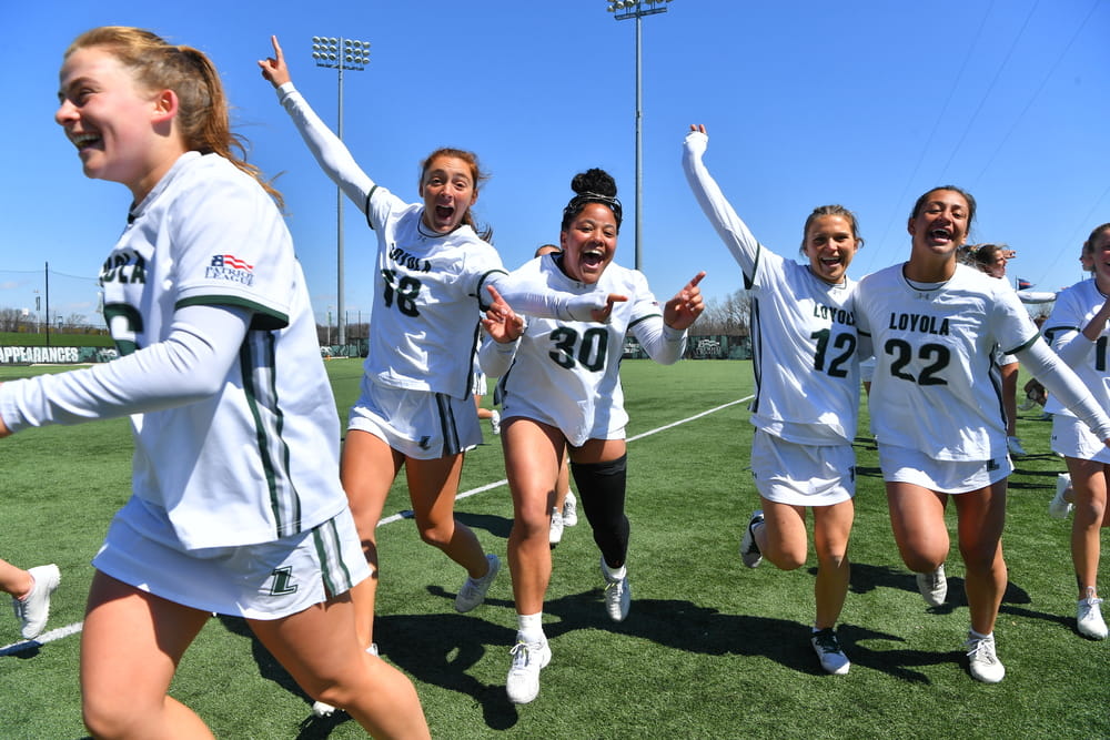 Members of the women's lacrosse team celebrate together after a victory.