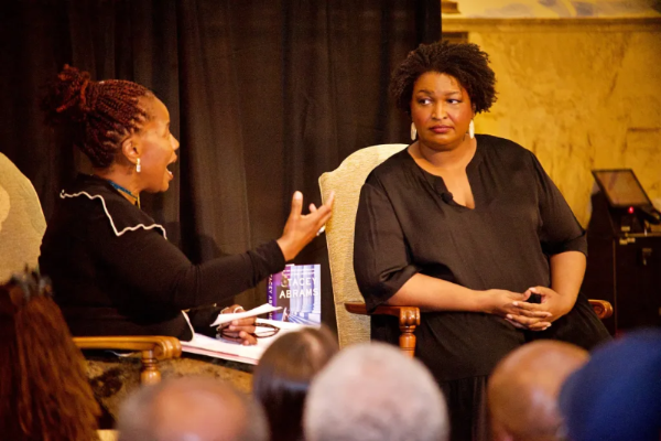 Dr. Whitehead talks to Stacey Abrams on stage at the Enoch Pratt Free Library's Writers LIVE! event. The book Rogue Justice is in the background.