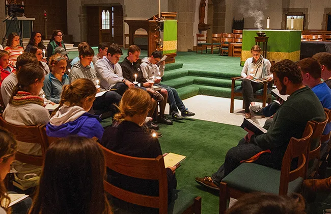 Students sitting in chairs during a chapel service
