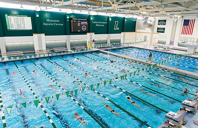 Students swim in pool lanes at Loyola's Fitness and Aquatic Center