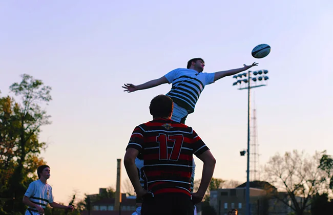 A Loyola rugby player leaps into the air to catch the ball