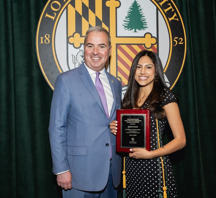 a lady holding a plaque beside a man in a suit