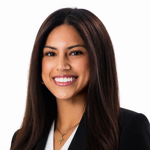 A lady with long hair,in black suit, smiling